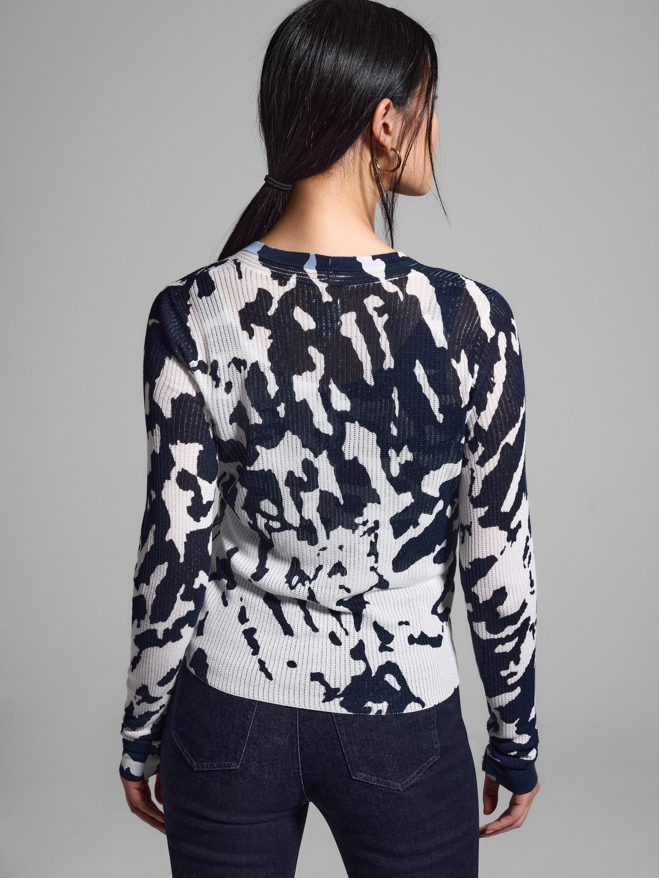 White and navy blue abstract print ribbed cardigan, long sleeves.  Seen from the back.