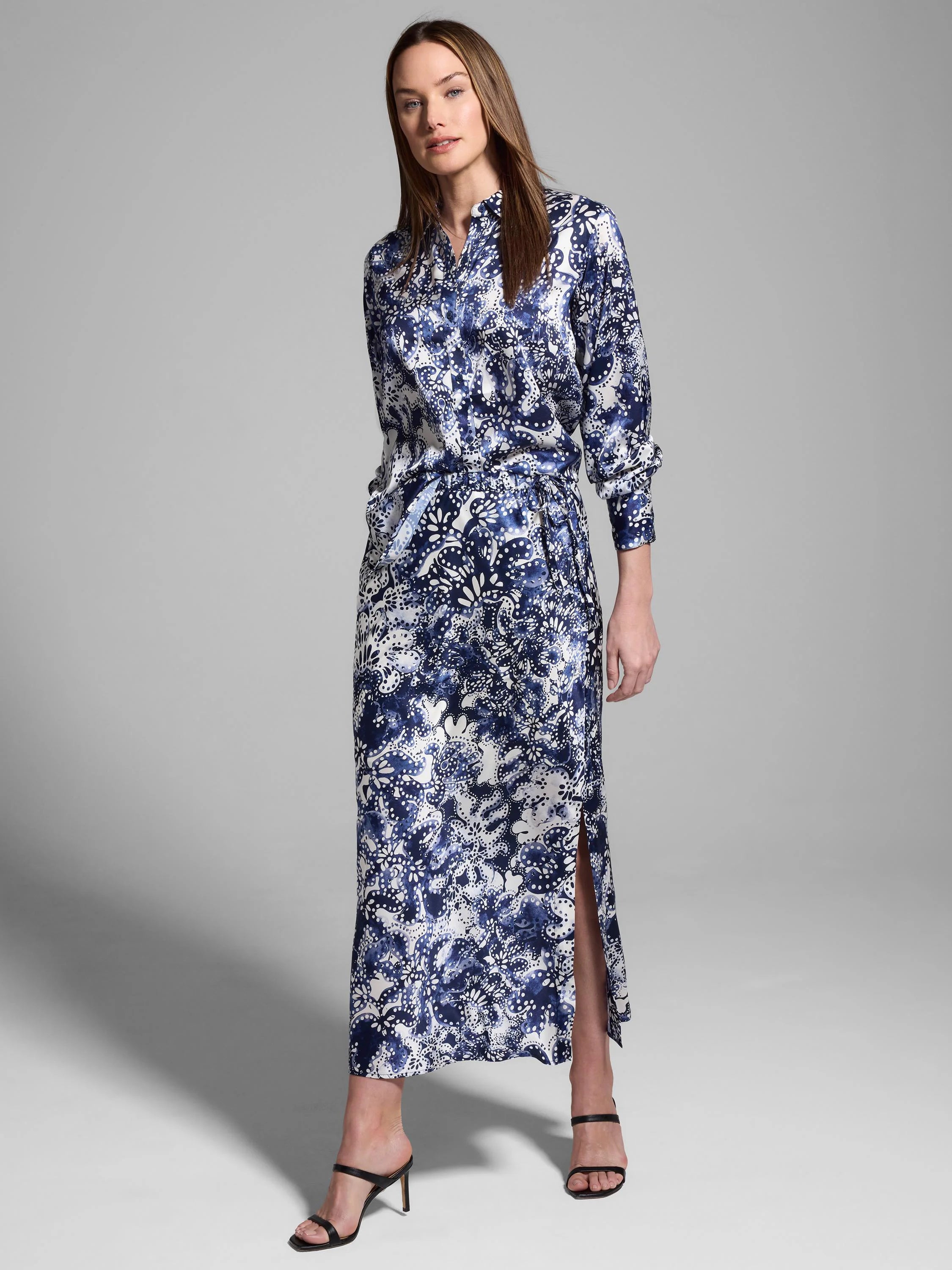 Silk shirt; long sleeves, maxi length, belted waist, side slit. Blue and white floral print on off-white background.