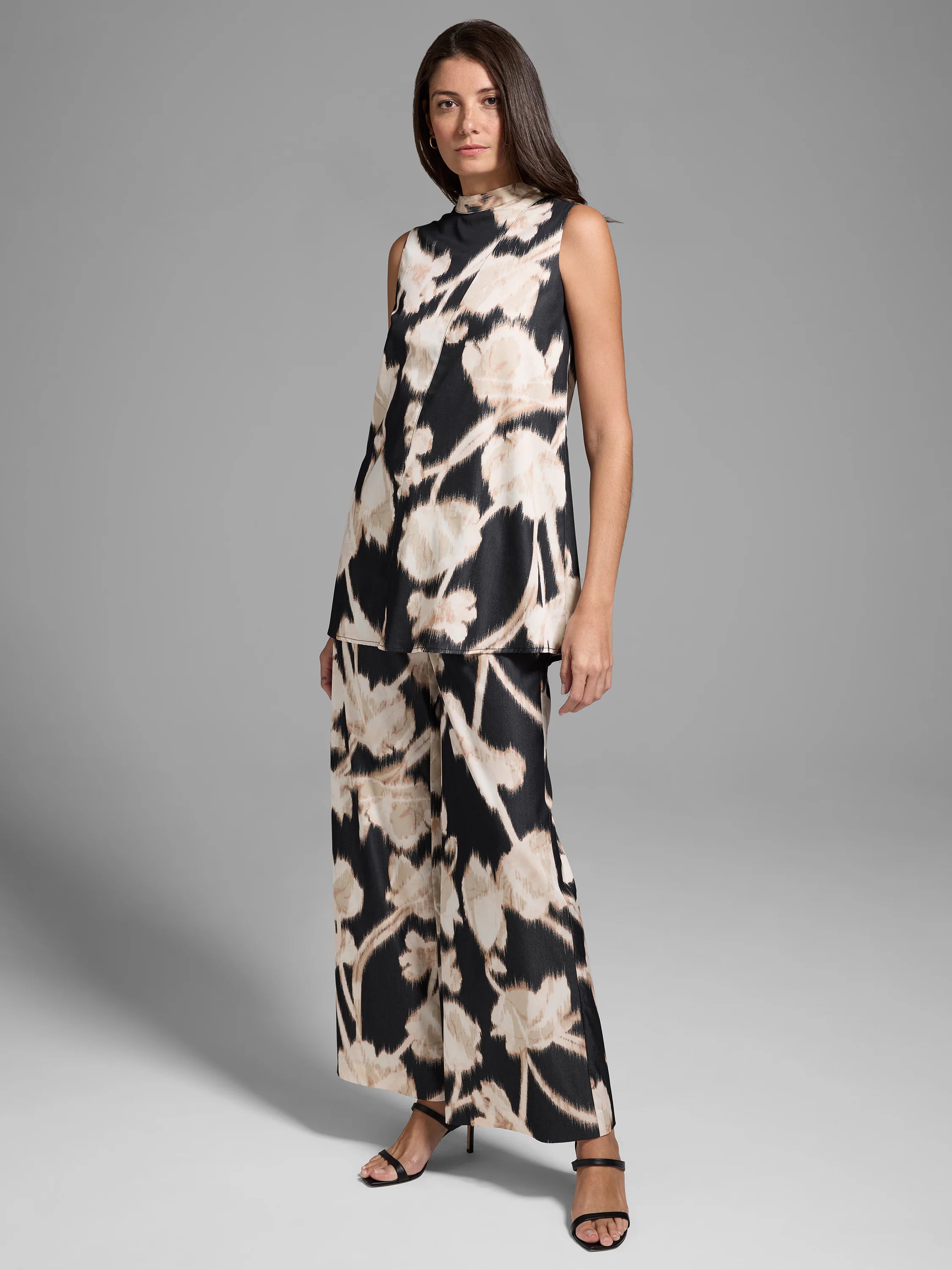 Wide-leg pants; black background with beige floral pattern.