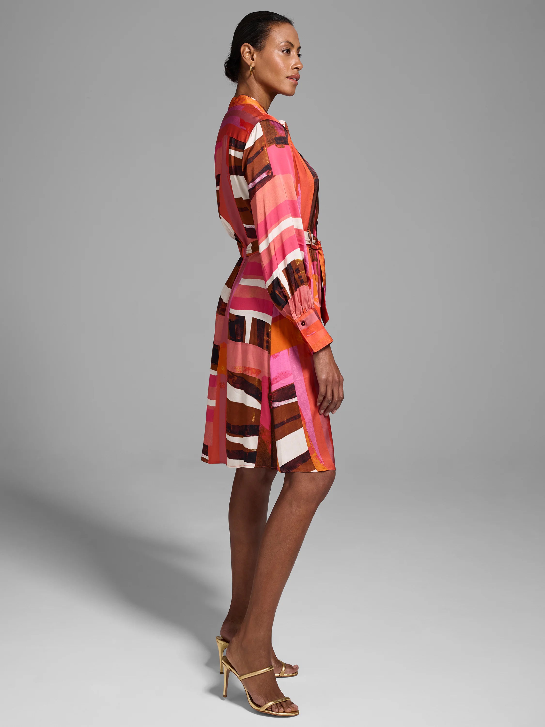 Short belted shirt dress in pink, orange, brown, and white abstract print.  Long sleeves.