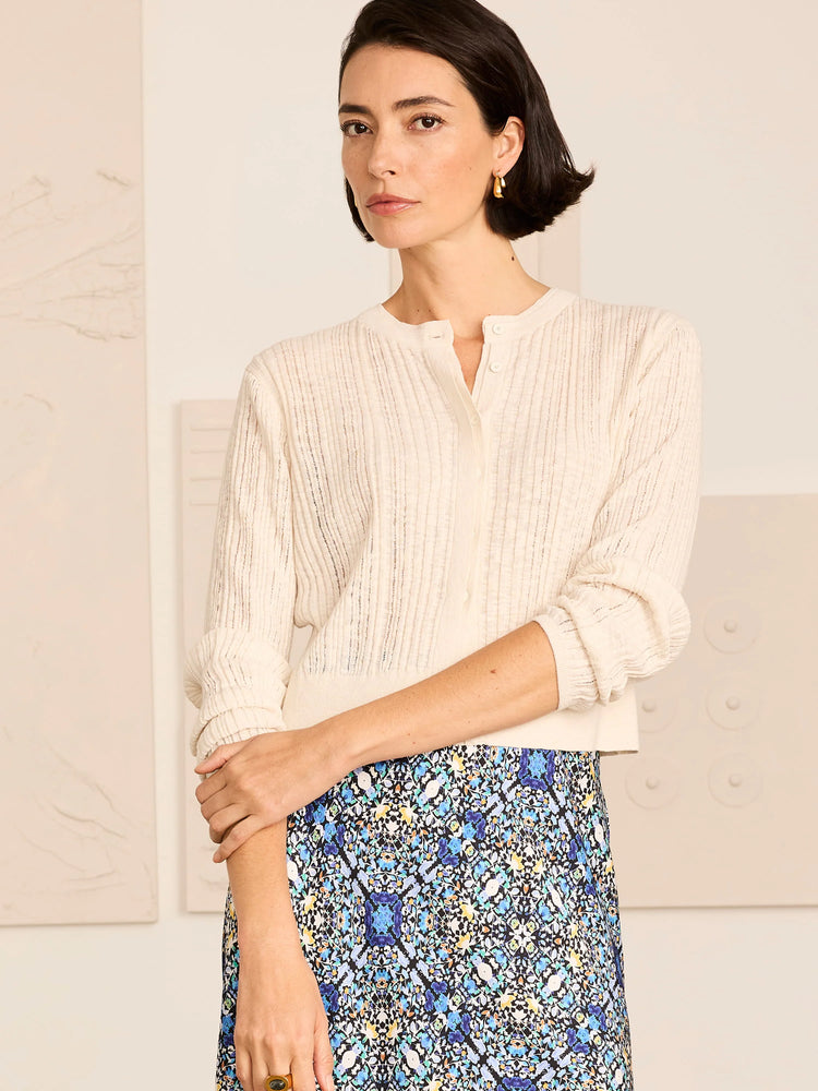 Cream pointelle knit cardigan with long sleeves and front buttons.