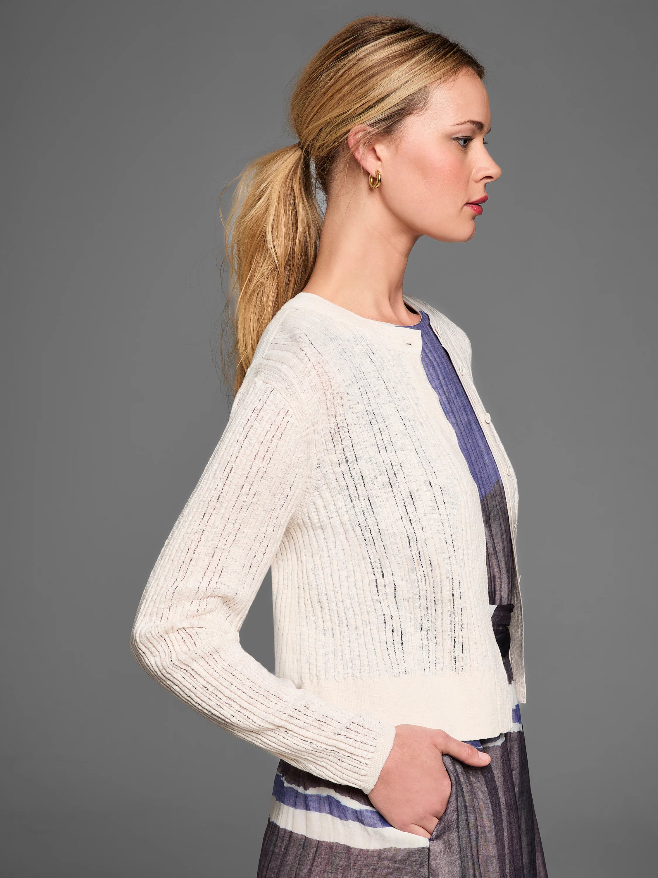Cream pointelle stitch cardigan with a delicate, semi-sheer openwork pattern and long sleeves.