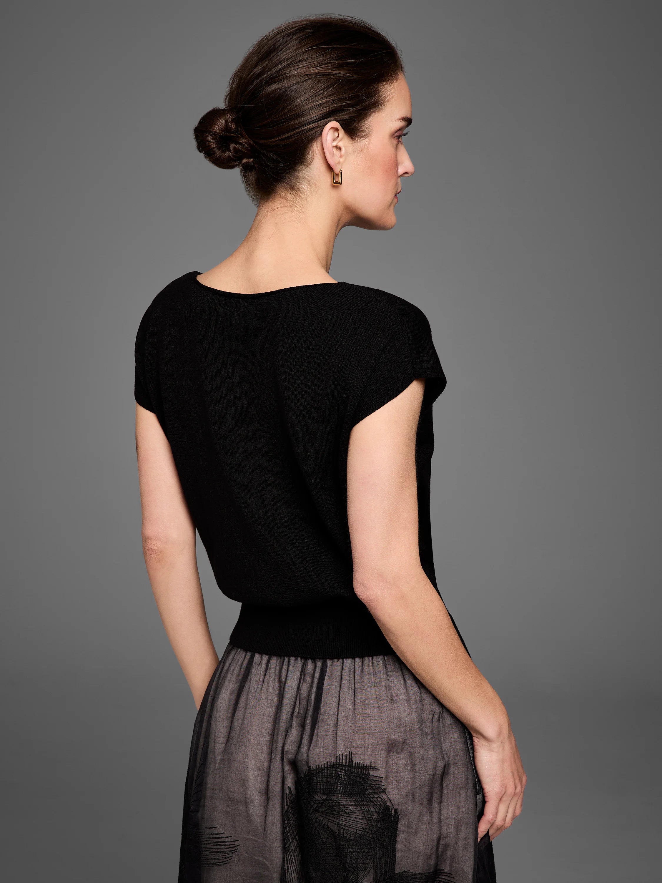 Black short-sleeved scoop neck sweater with a ribbed waist.