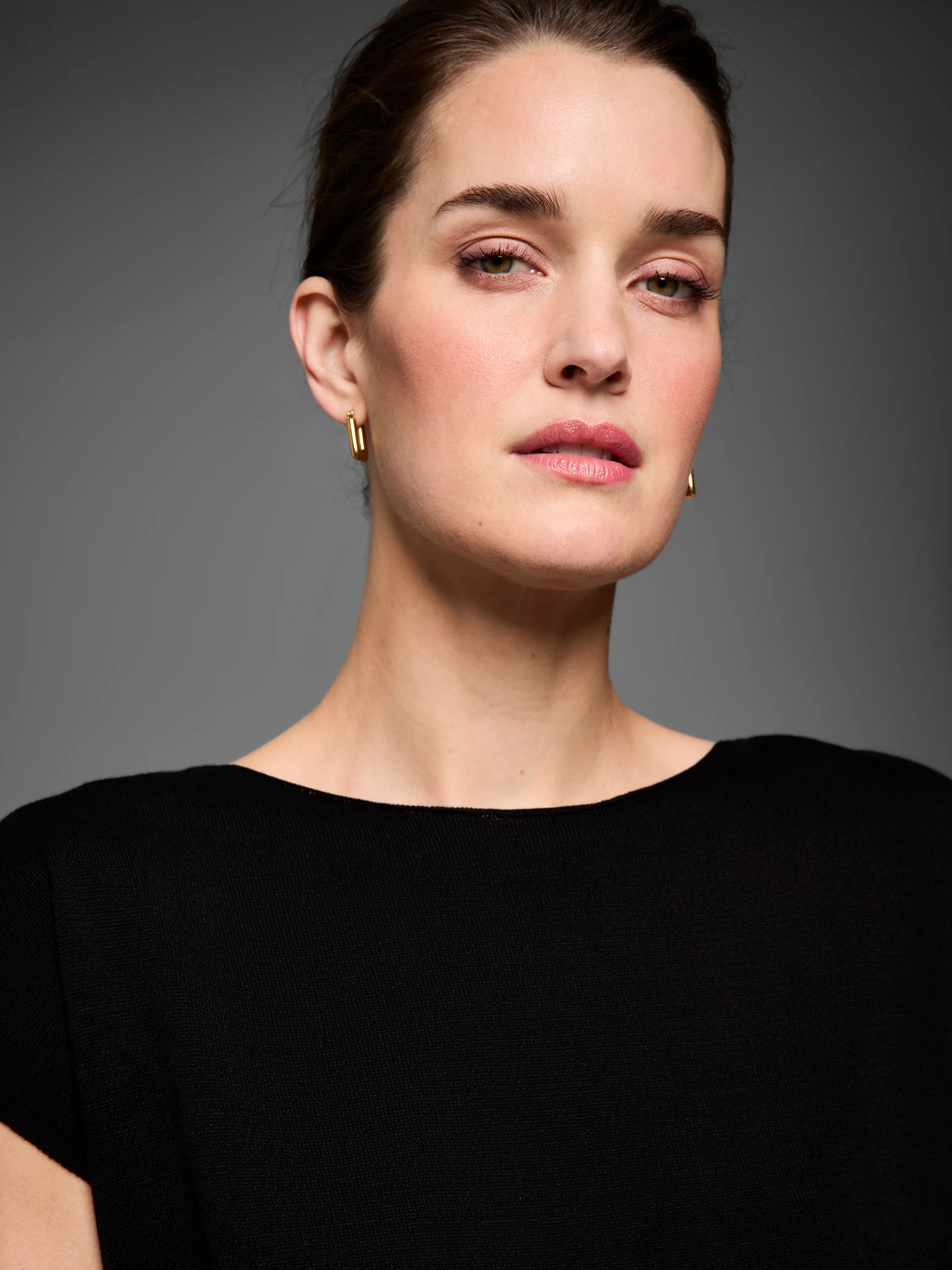 Black fine knit sweater on a model, featuring a wide neckline and short sleeves.