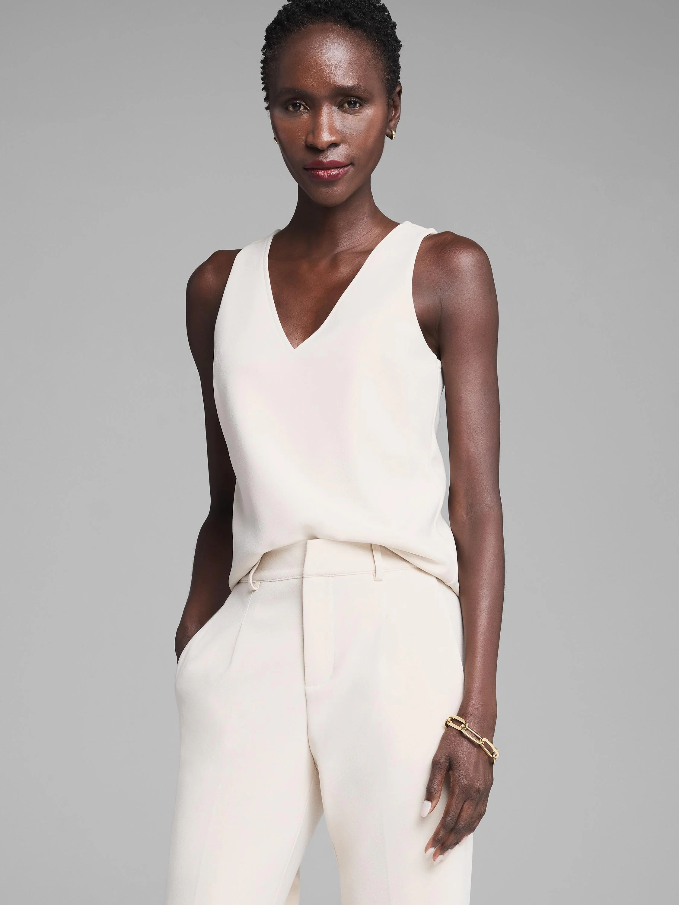 Ivory V-neck tank top with smooth scuba knit fabric. Sleeveless design.