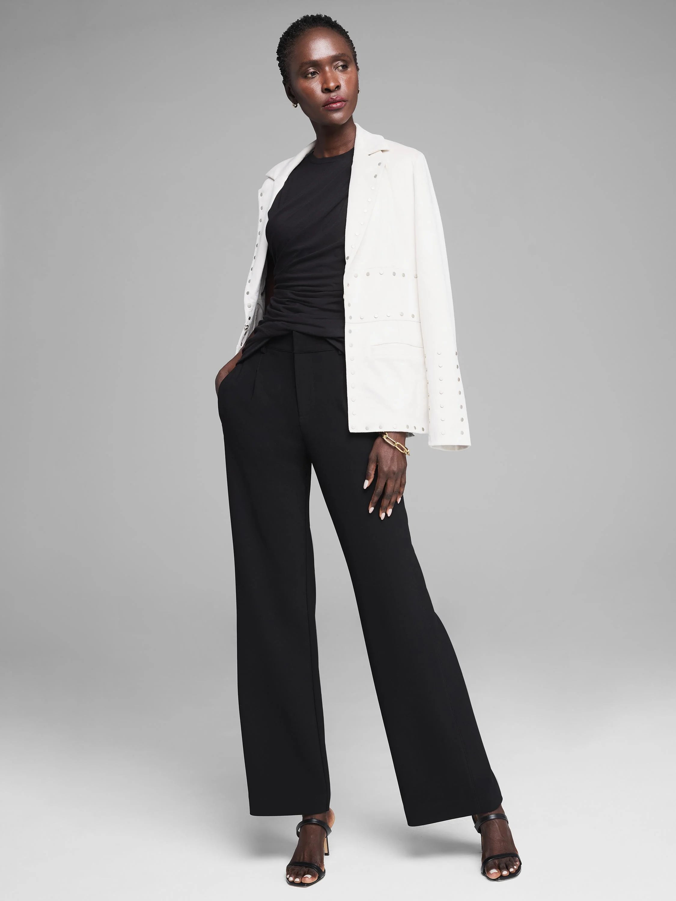 Black sleeveless jersey tank with extensive draping across the bodice and waist.