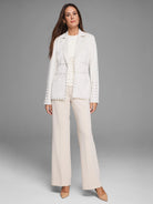 Cream jersey tank top with a high neck and soft, dramatically draped fabric on the front.