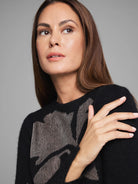 Black sweater with a shimmering gold lace knit floral pattern.