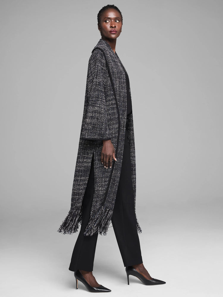 Long black & white woven jacket with black trim, featuring fringe on the hem and side slits.