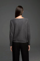 Dark grey knit sweater, viewed from the back on a model. Features a wide neckline, relaxed fit, and ribbed cuffs and hem.