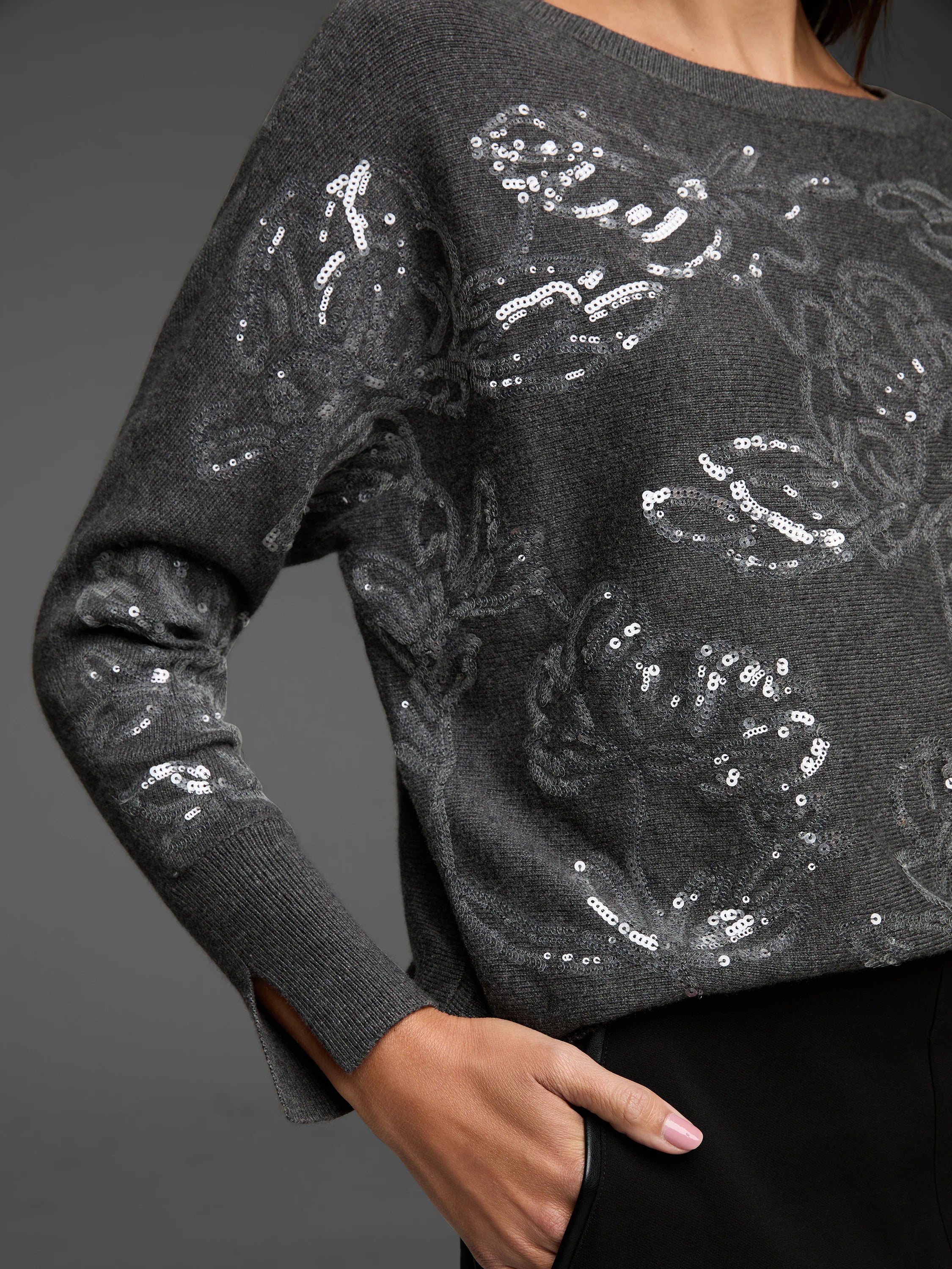 Dark gray knit sweater with silver sequin swirl pattern and boat neck.