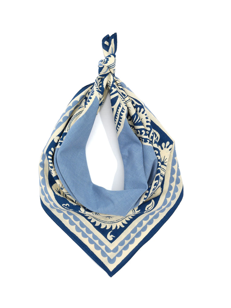Cream, dark blue, and light blue bohemian bandana. Features floral motifs and scalloped borders, tied at the top.