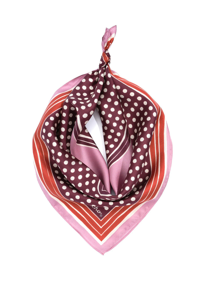 Burgundy bandana with white polka dots, pink, orange-red, and white striped border, tied at top.