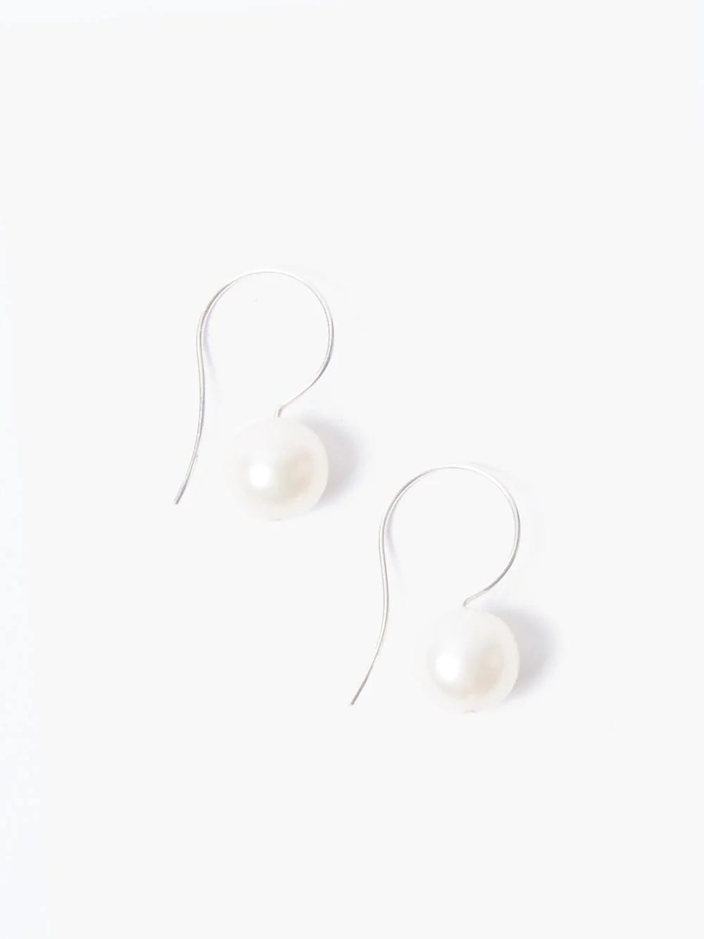 Pair of silver hook earrings, each with a single off-white pearl.