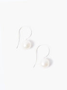 Pair of silver hook earrings, each with a single off-white pearl.