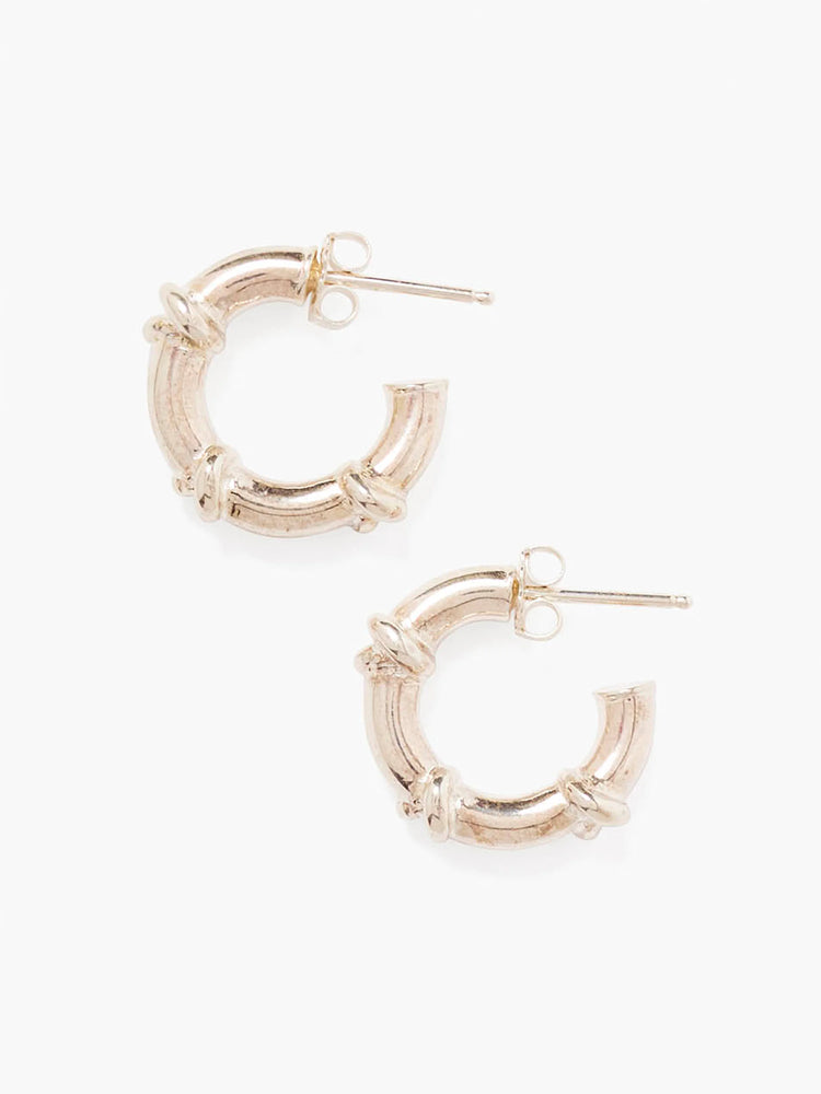 A pair of silver metal, C-shaped hoop earrings with textured segments wrapped around them.