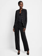 Black knit jacket with a band collar and a double row of silver buttons. Hip-length.