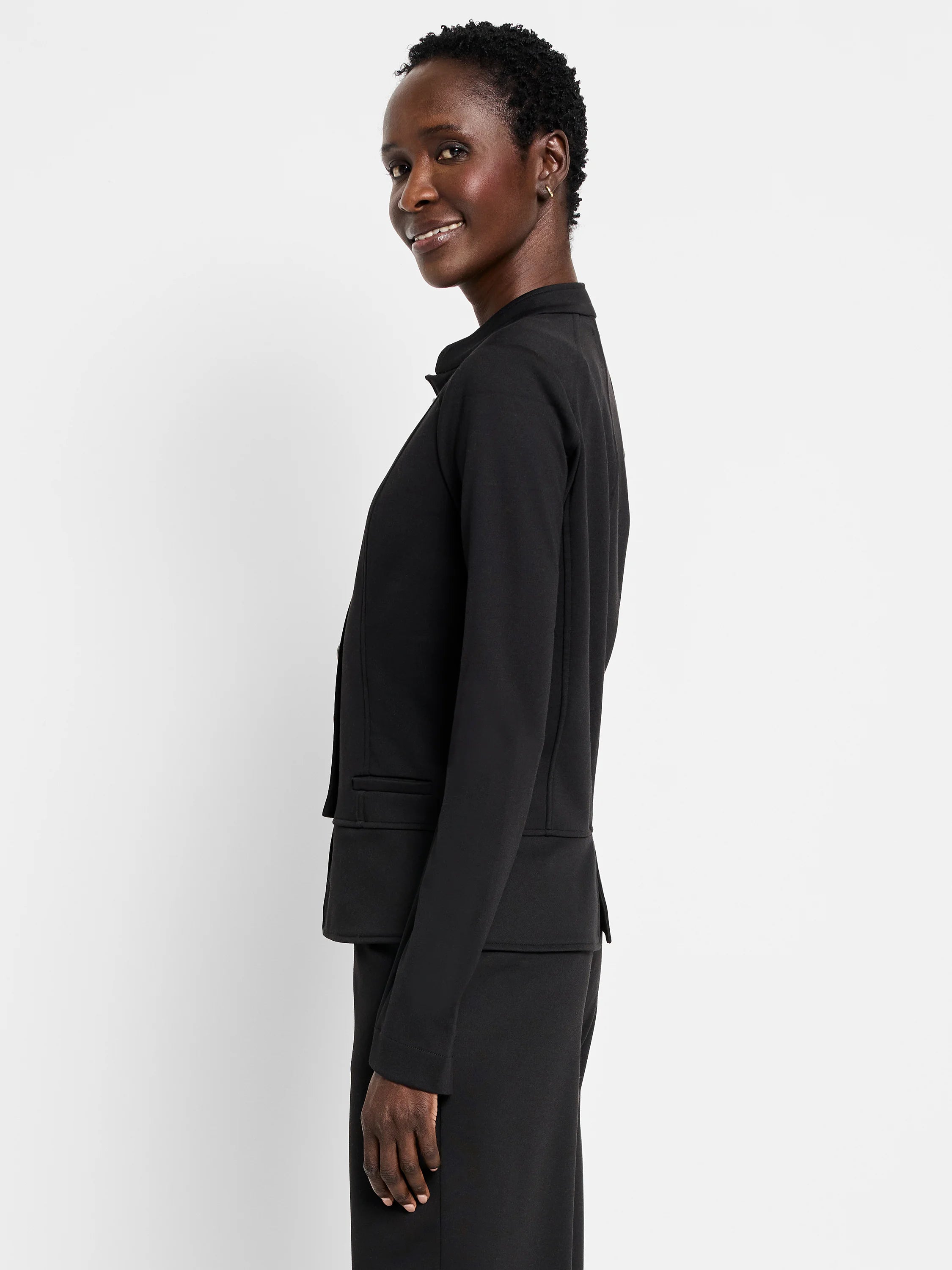 Black knit jacket with a stand collar, long sleeves, and two front flap pockets.