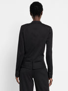 Black knit jacket, back view. Structured shoulders, horizontal seam above two back vents.