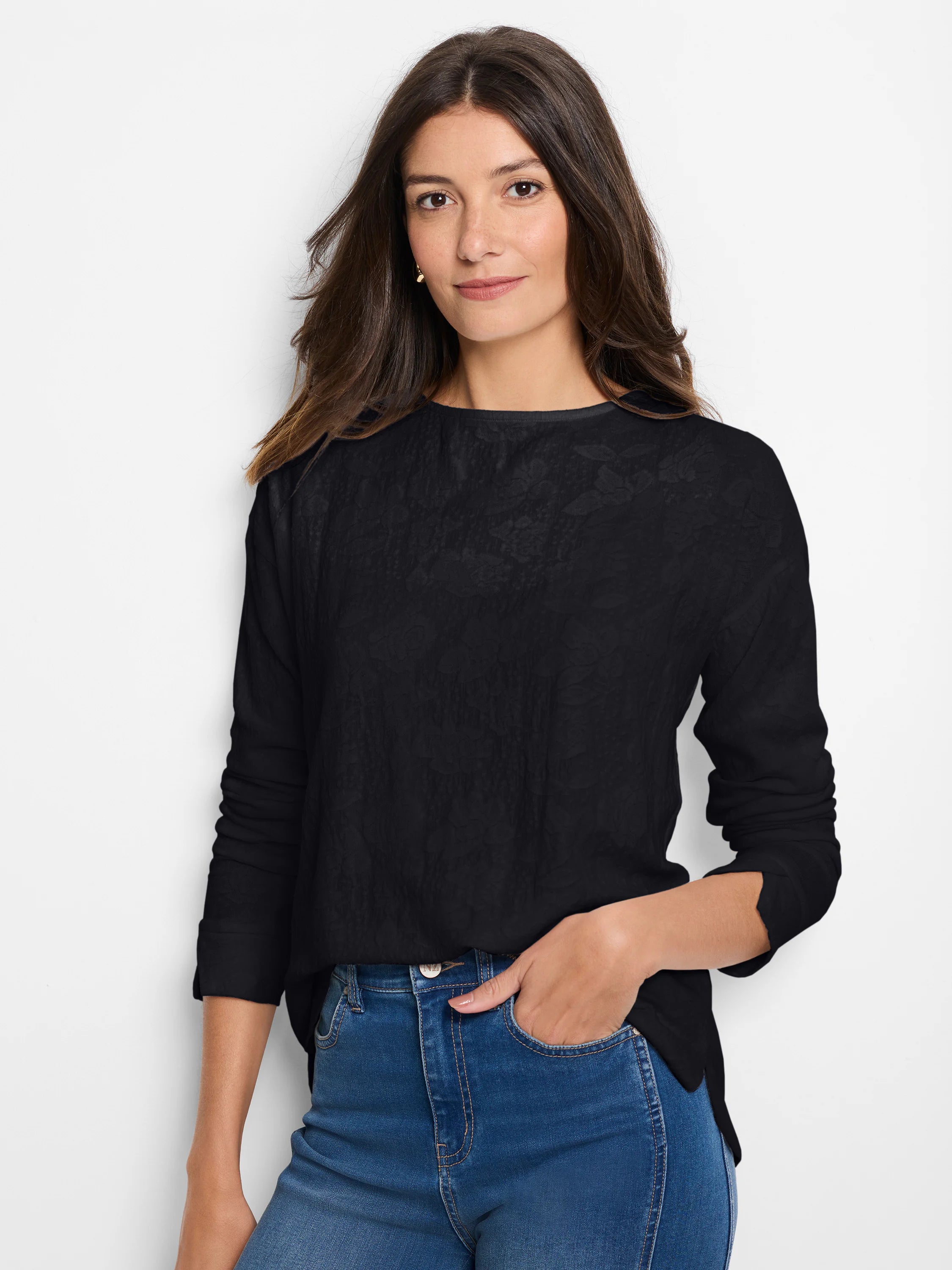 Black long-sleeve tee with a subtle, all-over lace knit texture and wide neckline, worn by a woman.