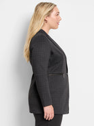 Dark gray knit jacket with thin white pinstripes, notched lapels, and a silver zipper pocket.