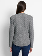 Black & white houndstooth plaid jacket, quilted with diamond stitching, seen from the back.