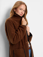 Brown teddy coat with black trim on the collar, front edge, and pockets.