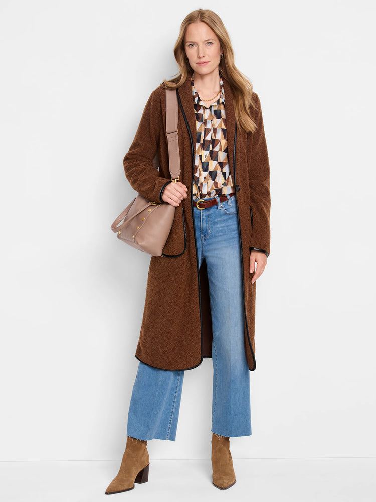 Long brown teddy coat with fuzzy texture and black trim along its edges.