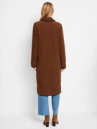 Long brown teddy coat with black trim on collar, cuffs, and hem. Model shown from behind.