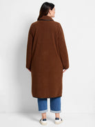 Brown, long teddy coat with fluffy texture and black trim details.