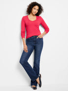Vibrant reddish-pink, long-sleeve, V-neck tee with subtle ribbed texture on a model.