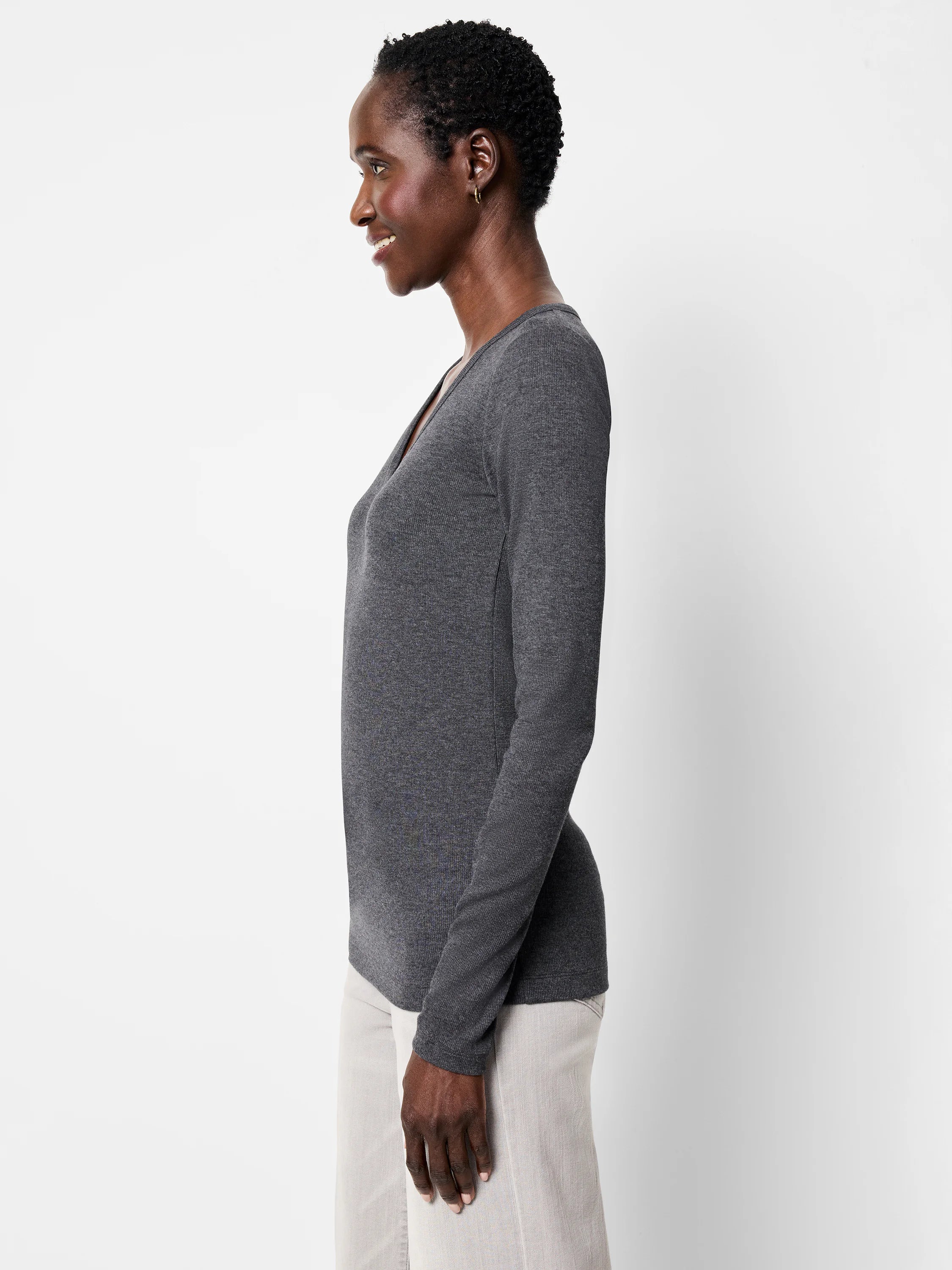 Dark gray rib knit long sleeve V-neck tee, fitted, on model in profile.