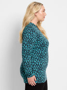 Teal long-sleeve top with black and purple animal print spots.