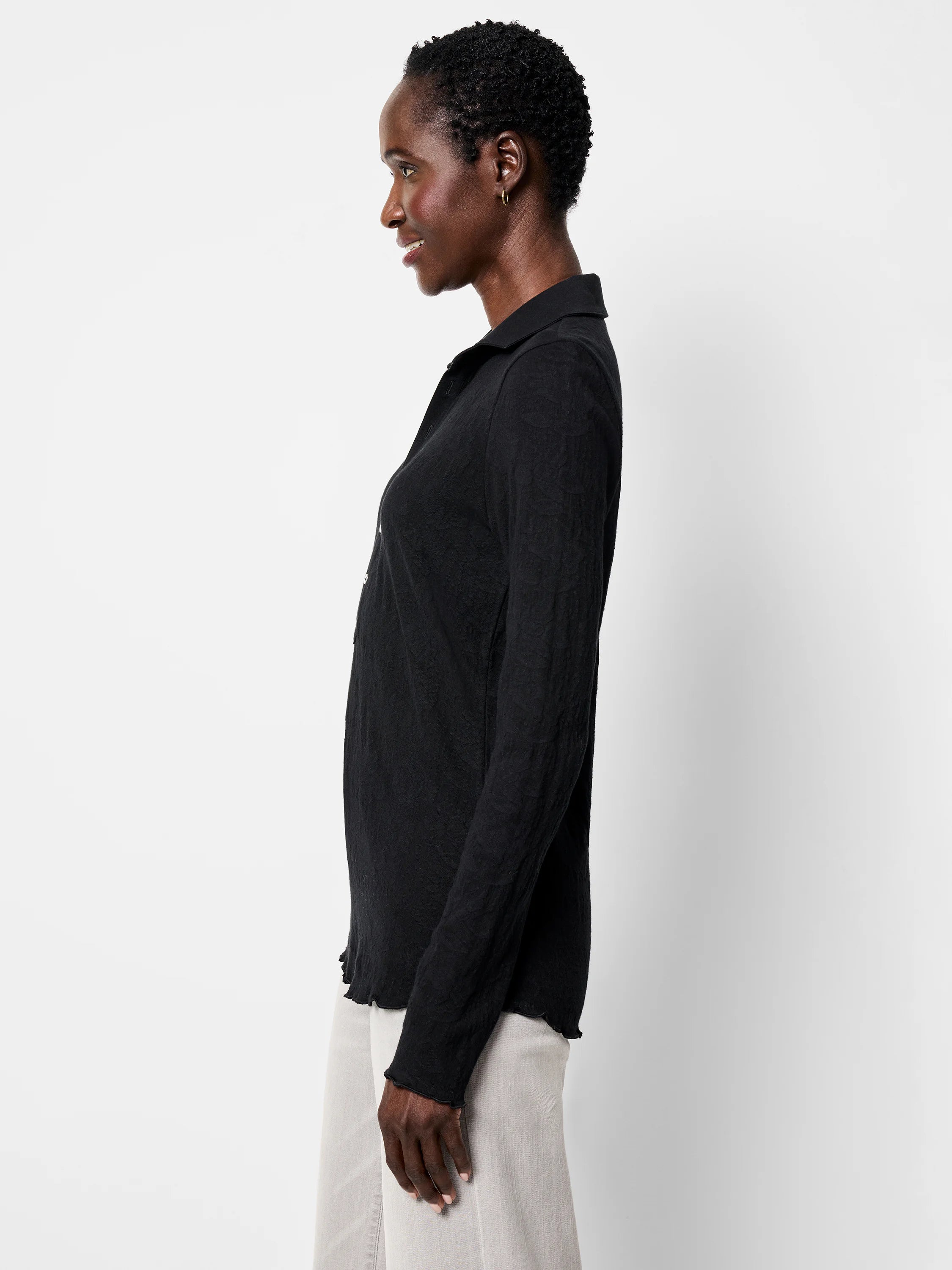 Black lace knit collared top with long sleeves, textured pattern, and wavy lettuce-edge trim on cuffs and hem.