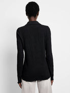 Back of black collared lace-knit top. Long sleeves, wavy lettuce-edge cuffs and hem.