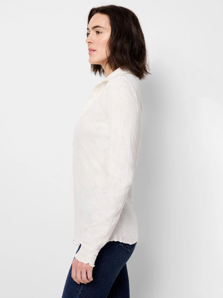 Off-white lace knit collared top with subtle floral texture, long sleeves, and wavy edges.