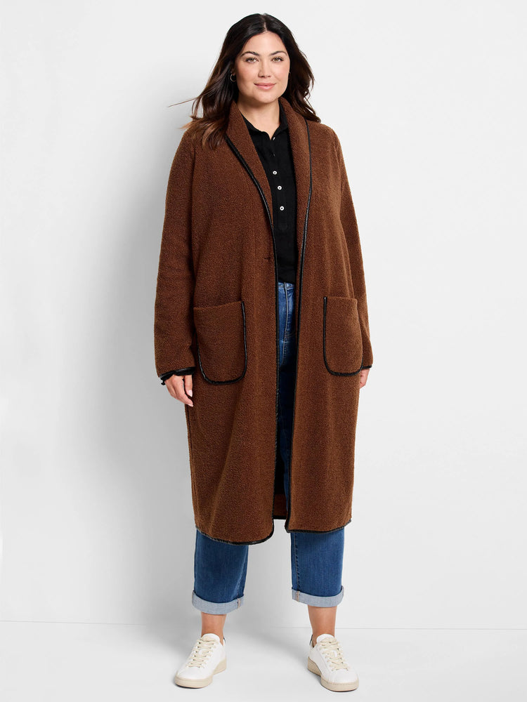 Black collared knit top, mostly covered by a long brown textured coat with black trim.