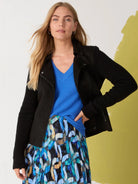 Black mixed media moto jacket with a smooth body, ribbed knit sleeves, and metal snap and zipper hardware.