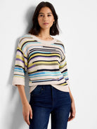 Ecru sweater with varied horizontal stripes in black, pale yellow, light blue, lavender, and olive. Features 3/4 sleeves.
