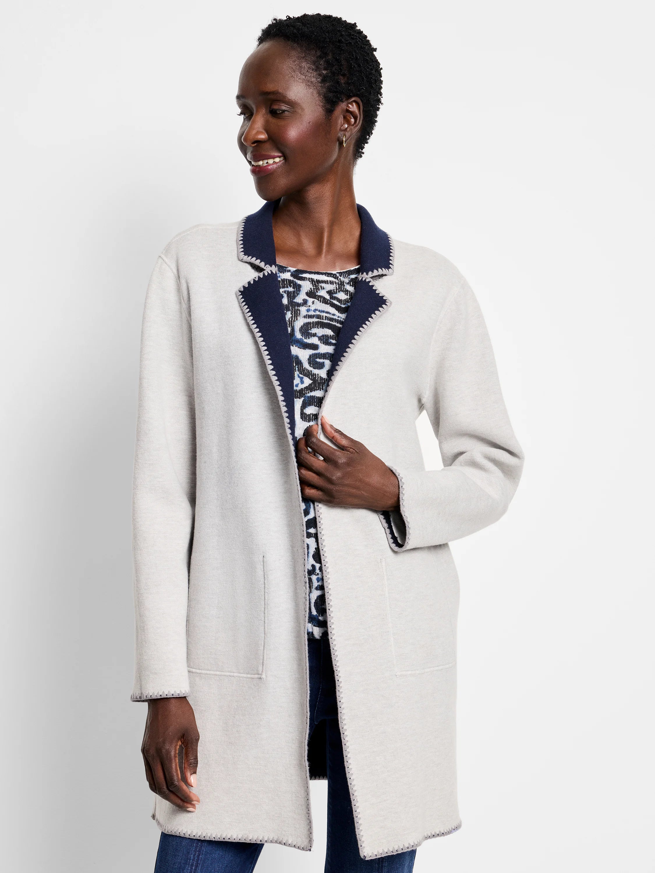 Oatmeal knit jacket with navy reversible lapels & cuffs. Contrast zigzag stitching visible on edges & pockets.