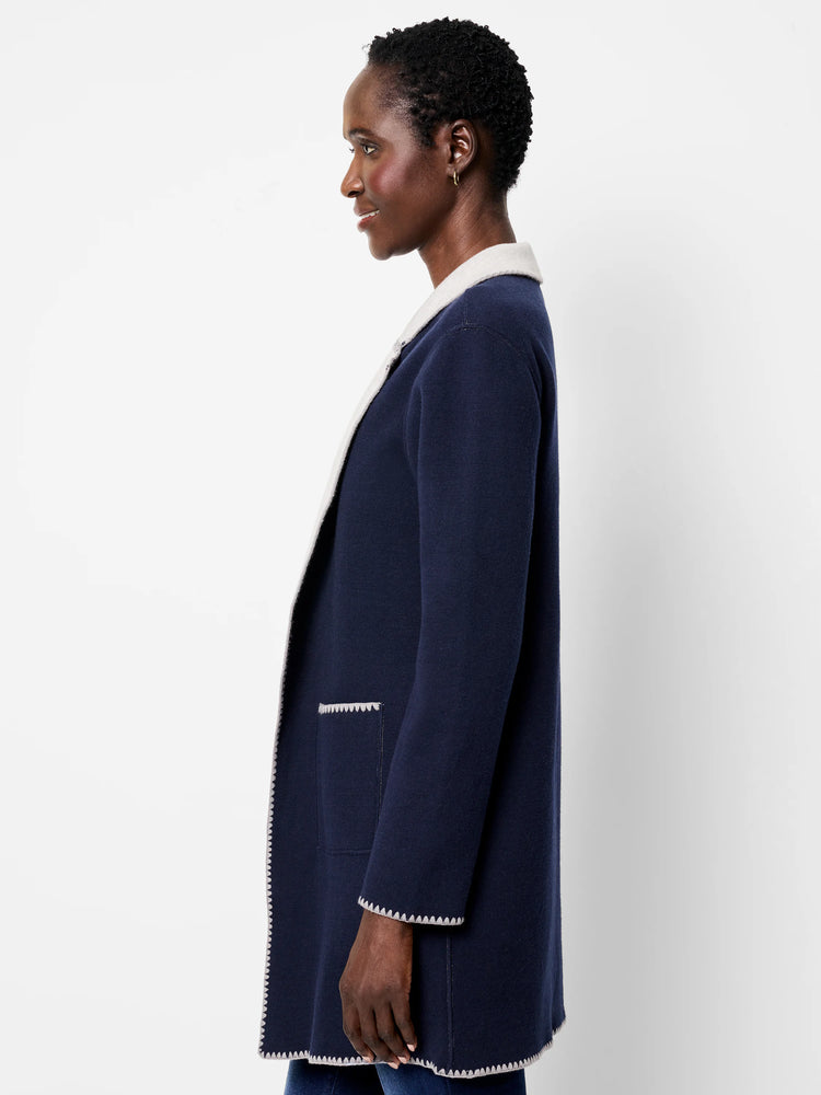 Navy reversible knit jacket with cream reverse. Cream scalloped trim on all edges and pocket.