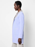 Light blue reversible knit jacket with gray interior. Features white scalloped stitching on edges and pocket.