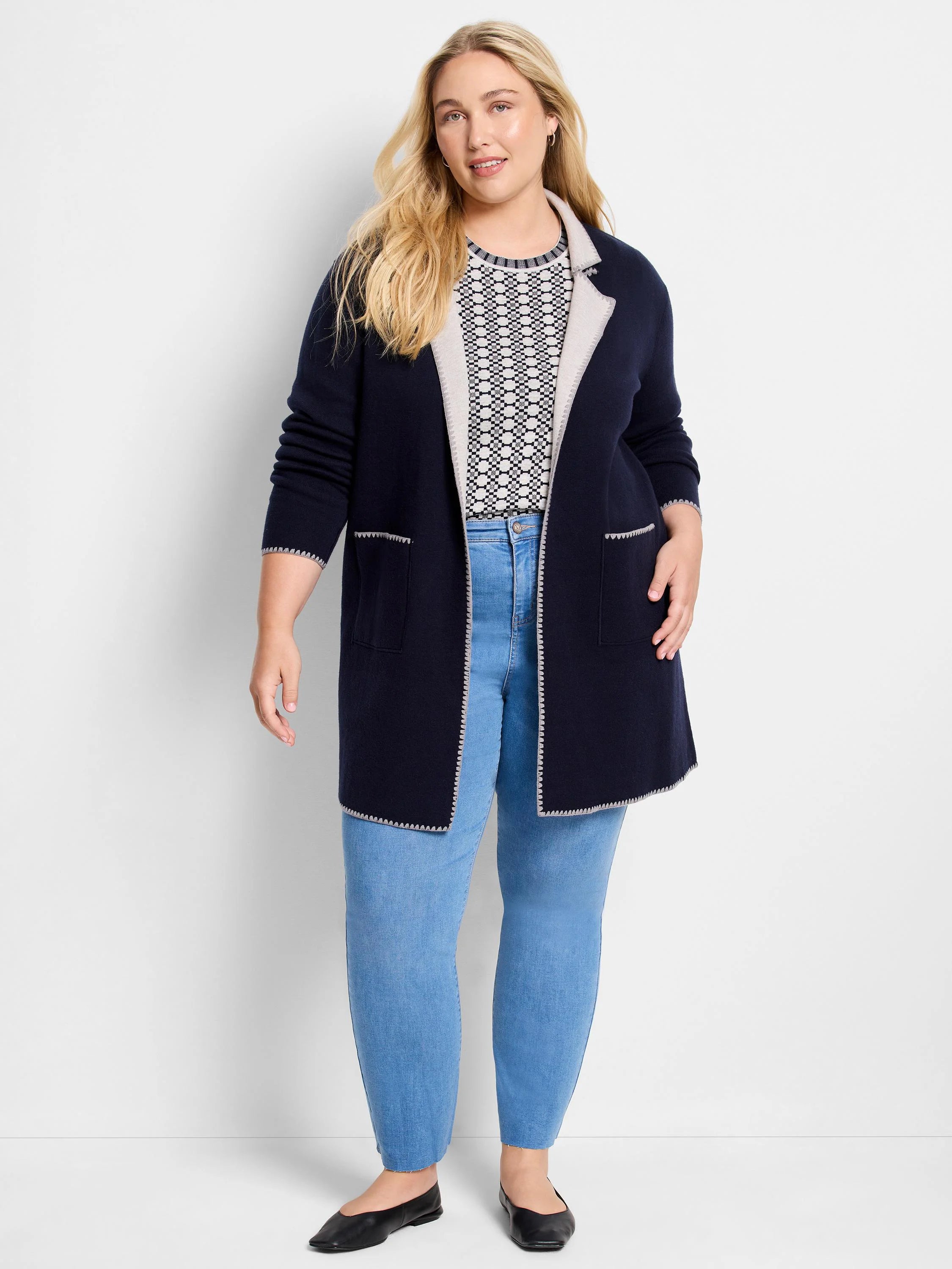 Navy open knit jacket with light contrasting lapels, cuffs, and hem. Features front patch pockets and decorative trim.