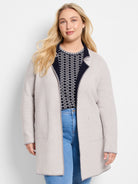 Light beige reversible knit jacket with navy interior trim. Features gray edge stitching and front pockets.