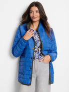 Bright blue quilted puffer jacket with olive green trim, snap buttons, and front patch pockets.