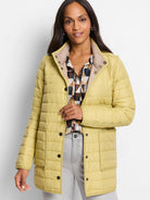 Light yellow puffer jacket with tan reversible side, stand collar, snap buttons, and patch pockets.