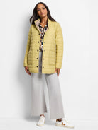 Pale lime reversible puffer jacket with dark snap buttons, stand collar, and front patch pockets. Beige reverse side.