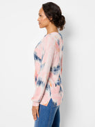 Pink waffle stitch sweater with abstract blue & orange pattern, long sleeves, and side slits.