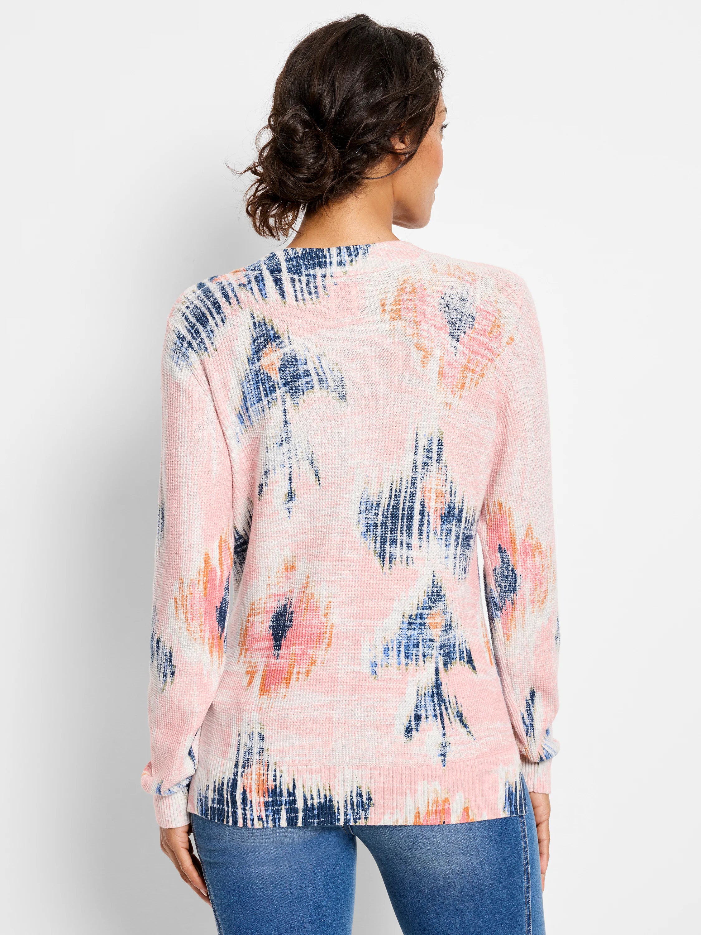 Back of pink waffle-knit sweater with abstract navy, light blue, and orange pattern.