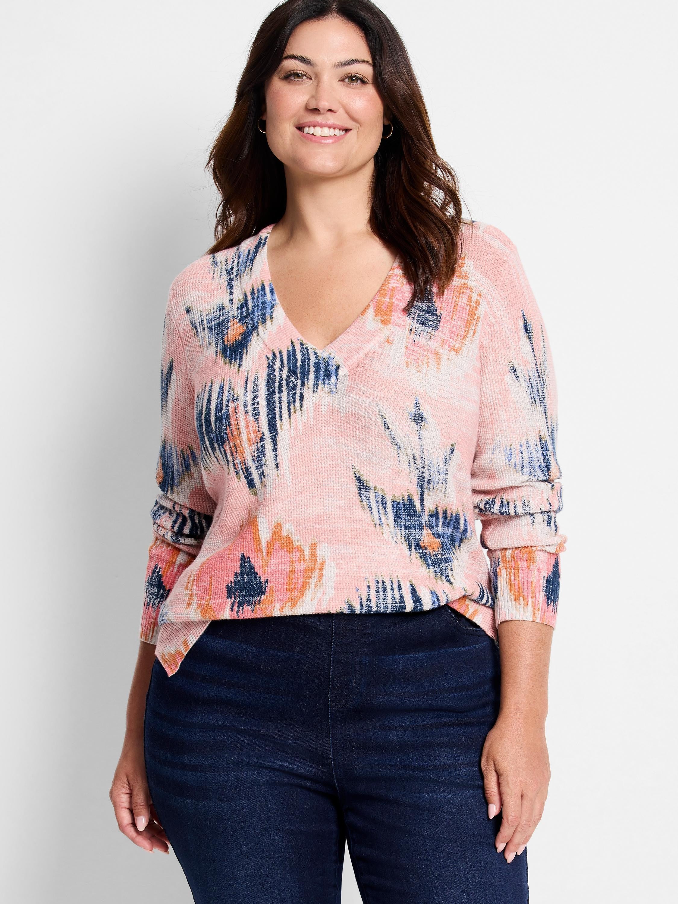 Light pink waffle knit V-neck sweater with bold, abstract brushstrokes in navy, light blue, orange, and white.